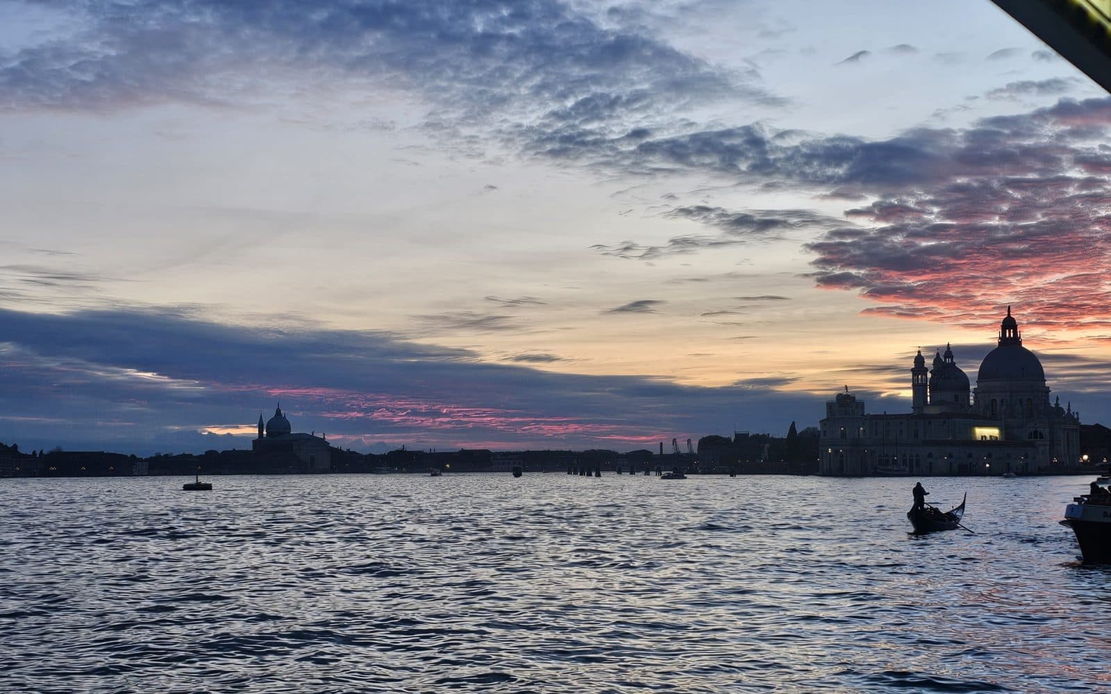 Venecia al atardecer desde el vaporetto, con la basílica de la Salute al fondo, febrero de 2026