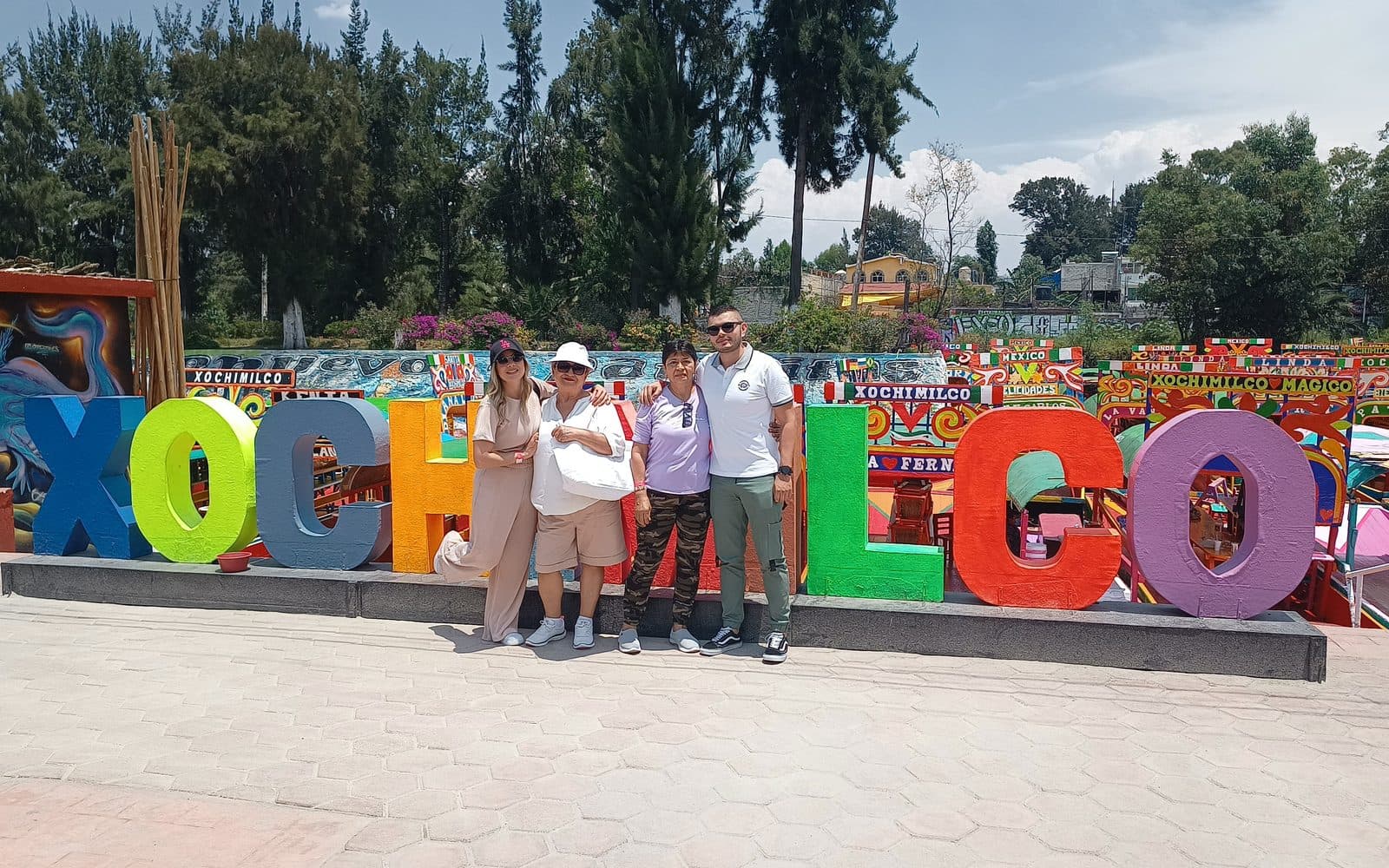 Los cuatro en el letrero de Xochimilco, con las trajineras al fondo, Ciudad de México, abril de 2023