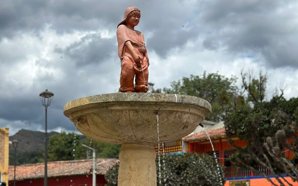 La fuente de la plaza de Ráquira, con las casas de colores al fondo, 9 de junio de 2024