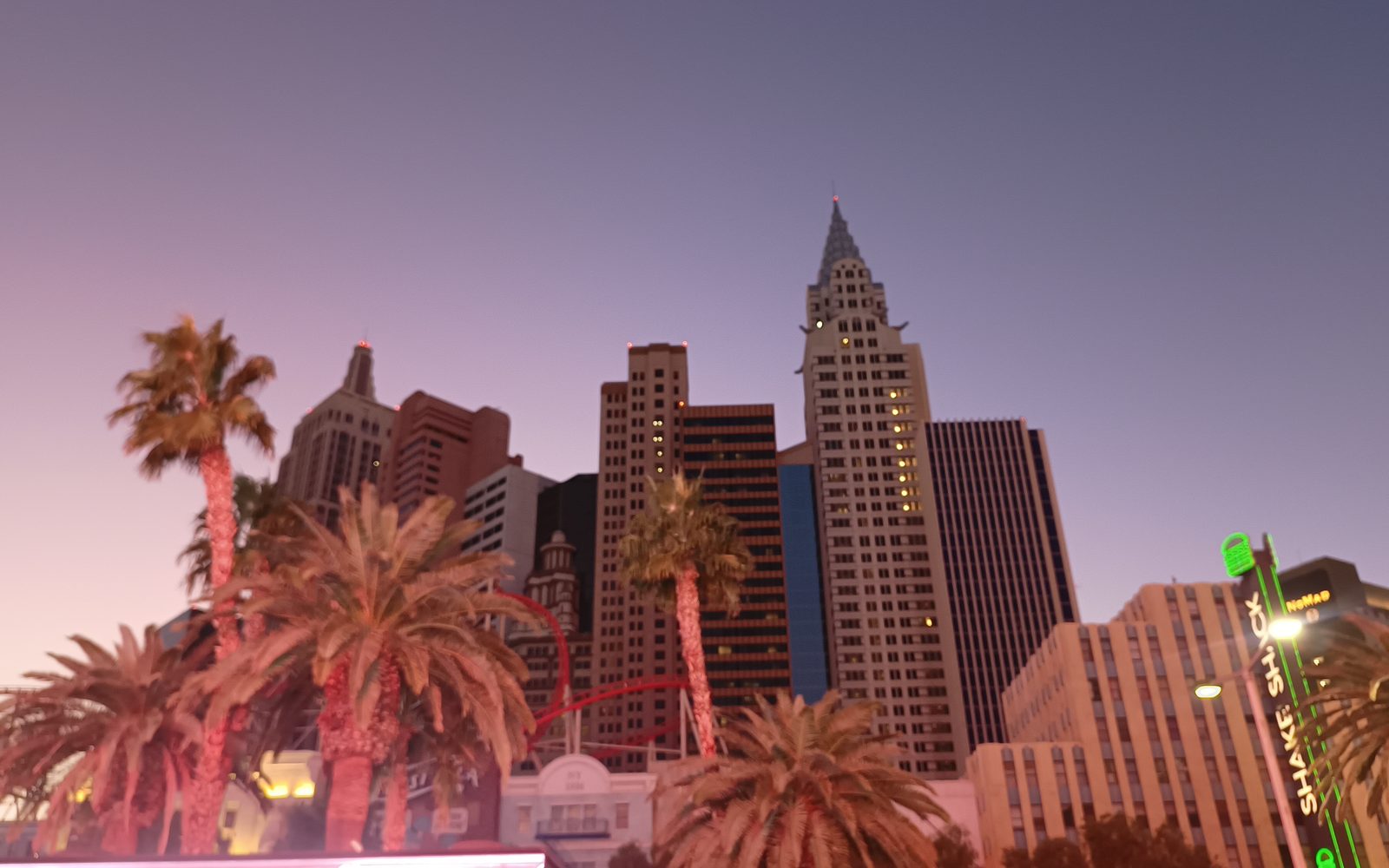 El hotel New York-New York al atardecer, con las palmeras del Strip en primer plano, 23 de noviembre de 2023